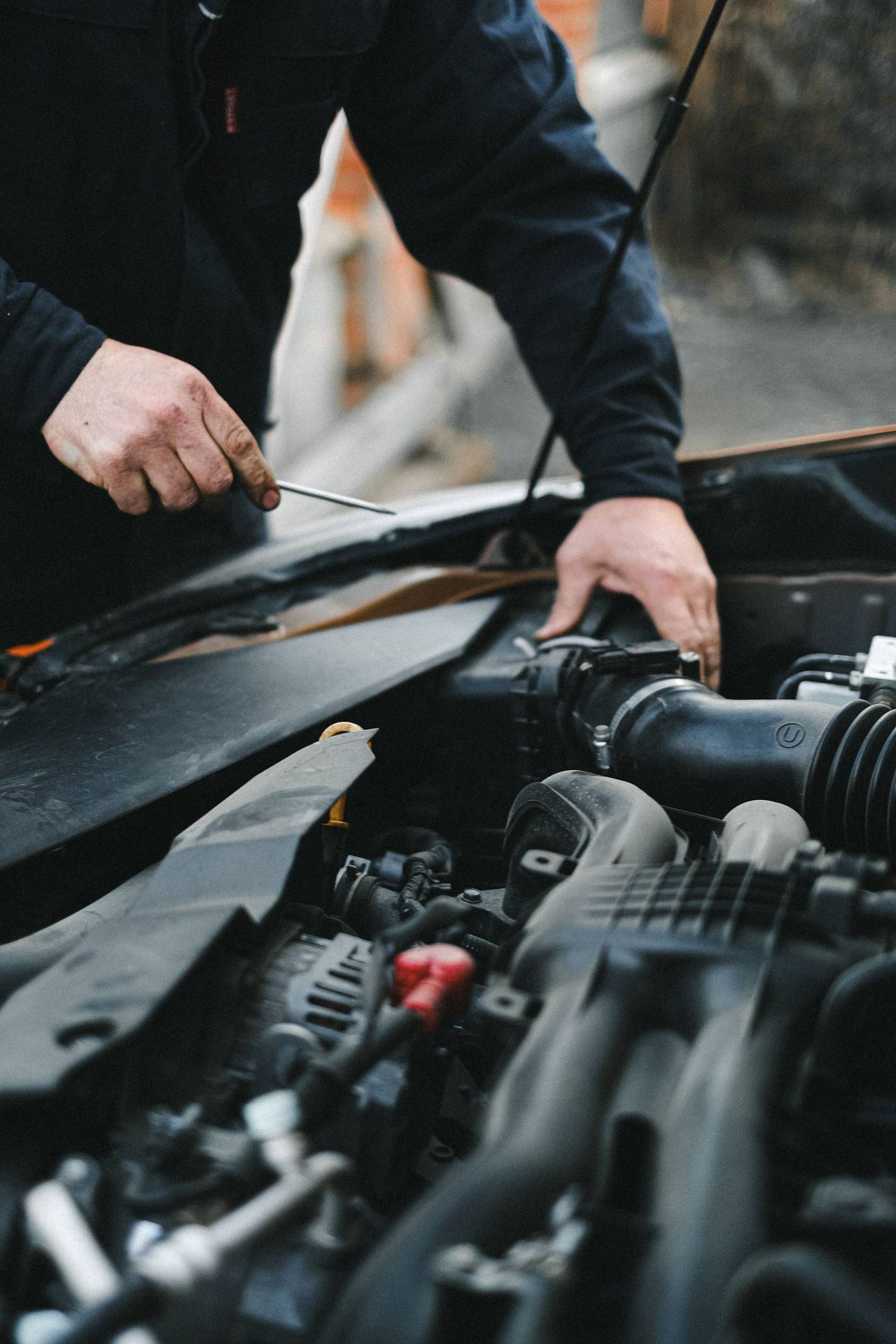 Hände bei der Arbeit im Motorraum